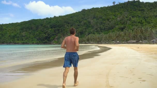 Hombre corriendo en la playa. — Vídeo de stock