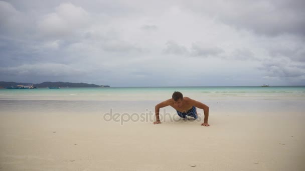 Человек делает отжимания на пляже — стоковое видео