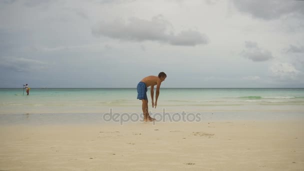 Man doet ochtendoefeningen op het strand. — Stockvideo