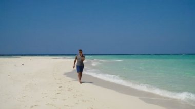 Adam sahilde bir cep telefonu ile.