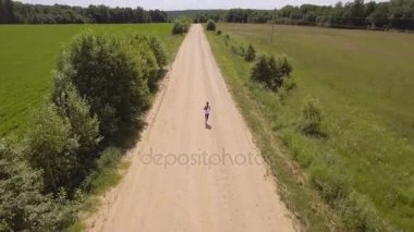 Kız bir alan yolu üzerinde çalışır. Havadan görünümü.