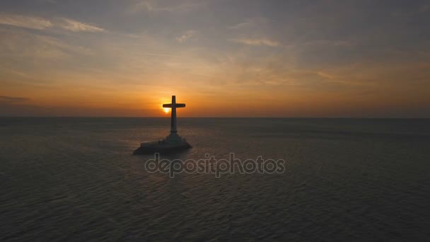 Katholieke kruis in de zee bij zonsondergang. — Stockvideo