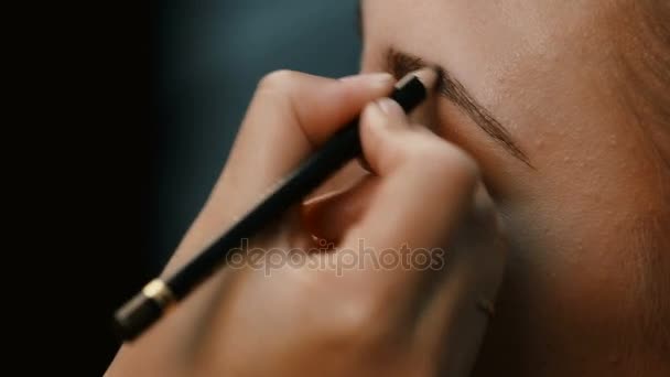 Makyöz, genç bir kadının profesyonel makyajını yapıyor. — Stok video