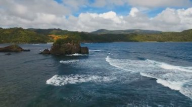 Tropik ada, kayalar ve dalgalar deniz manzarası. Catanduanes, Filipinler.