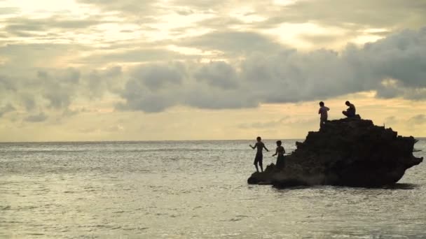 Τα παιδιά πάνω σε ένα βράχο στην αλιεία στη θάλασσα. — Αρχείο Βίντεο