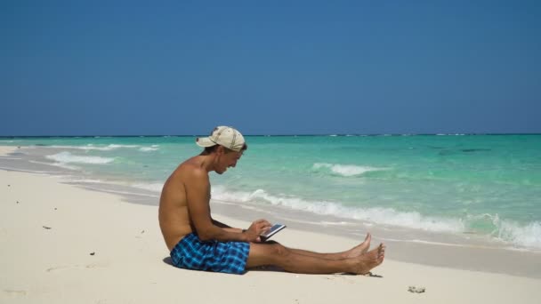 Hombre con la tableta en la playa — Vídeo de stock