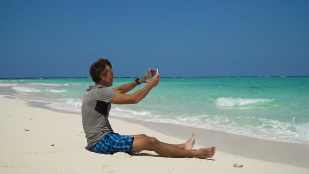 Hombre con la tableta en la playa — Vídeos de Stock