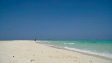 Kumsalda koşan adam.