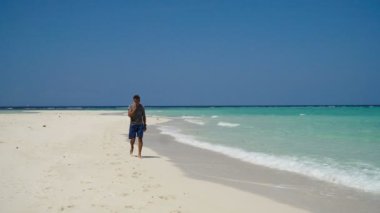 Adam sahilde bir cep telefonu ile.