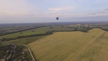 Sıcak hava balonu gökyüzüne bir buğday alanın üzerinde. Havadan görünümü