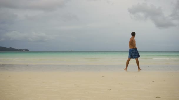 Uomo che fa esercizi mattutini in spiaggia. — Video Stock