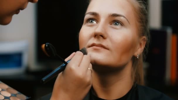 Makyöz, genç bir kadının profesyonel makyajını yapıyor.. — Stok video