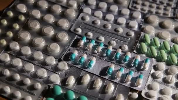 Envase de tabletas y pastillas sobre la mesa — Vídeo de stock