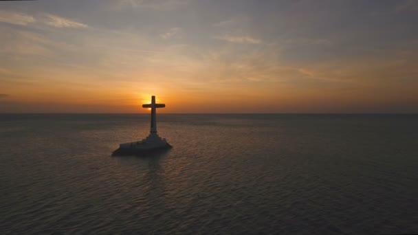 Katolik haç ve günbatımı denizde. — Stok video