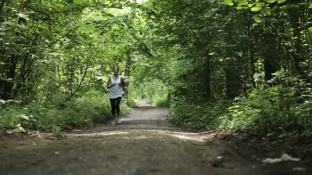 Chica corre en la carretera en un campo . — Vídeos de Stock