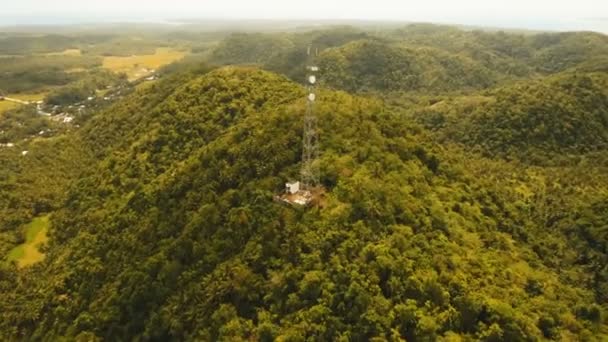 Telefon wieża sygnalizacyjna wśród zielonych lasów i gór. Widok z lotu ptaka. Siargao island, Filipiny. — Wideo stockowe