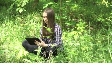 Kız bir tablet ormanda kullanır..