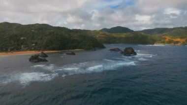 Tropik ada, plaj, kayalar ve dalgalar deniz manzarası. Catanduanes, Filipinler.