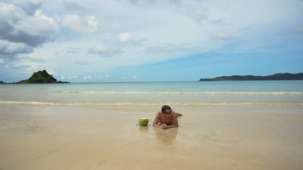 Mann liegt am Strand. — Stockvideo