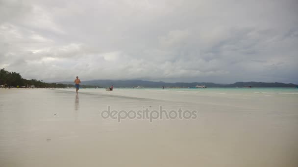 Muž běžící na pláži. — Stock video