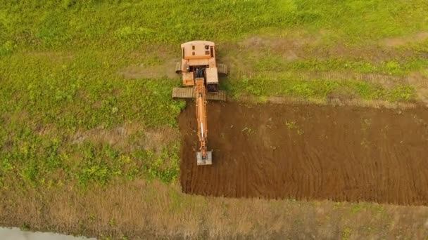 Excavadora cavando una zanja en el campo.Vídeo aéreo . — Vídeos de Stock