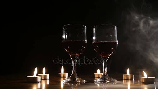 Weingläser und brennende Kerzen im Rauch. — Stockvideo