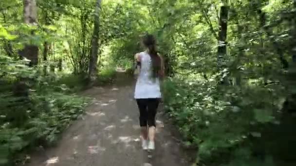 Menina corre na estrada em um campo . — Vídeo de Stock