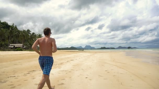 Homem correndo na praia. — Vídeo de Stock