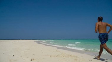 Kumsalda koşan adam.