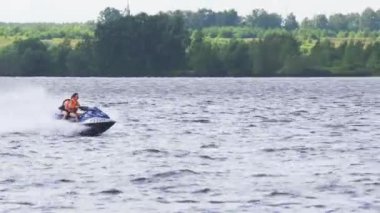 Göl kenarında jet ski üzerinde biniciler.