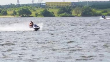 Göl kenarında jet ski üzerinde biniciler.