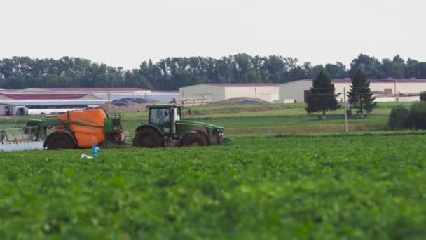 Tractor sproeit kunstmestveld. — Stockvideo