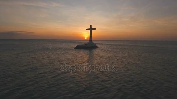 Catholic cross in the sea at sunset. — Stock Video