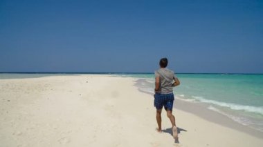 Kumsalda koşan adam.