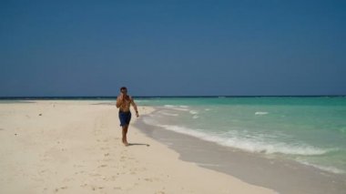 Adam sahilde bir cep telefonu ile.