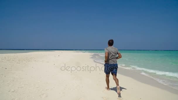 Hombre corriendo en la playa. — Vídeo de stock