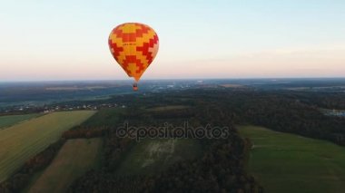 Sıcak hava balonu bir alanın üzerinde gökyüzünde.
