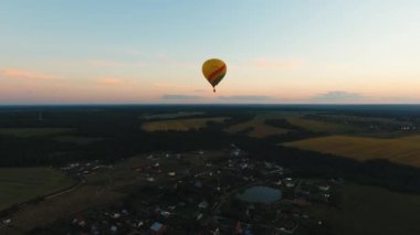 Sıcak hava balonu bir alanın üzerinde gökyüzünde.