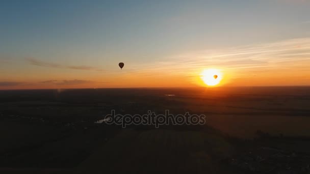 Balão de ar quente no céu sobre um campo . — Vídeo de Stock