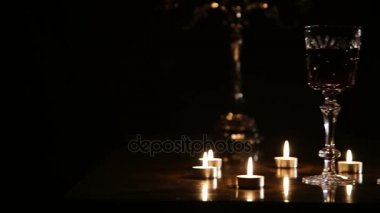 Şarap, gözlük ve yanan mumlar.