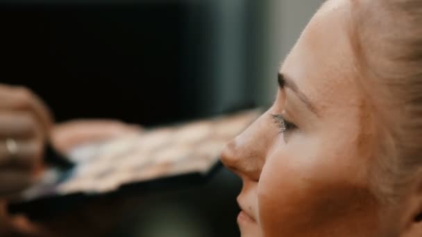 Makyöz, genç bir kadının profesyonel makyajını yapıyor.. — Stok video