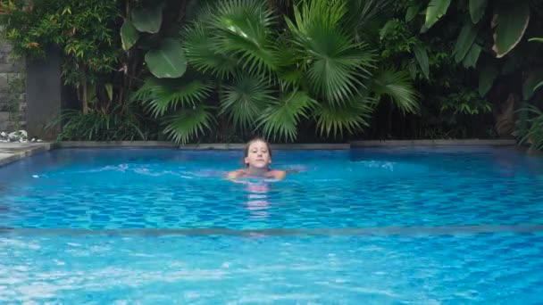 女孩在游泳池里游泳. — 图库视频影像