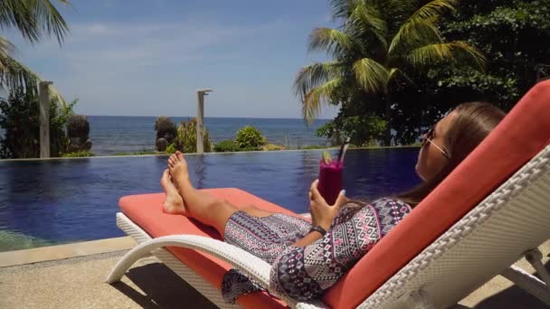 Ragazza con un bicchiere di cocktail vicino alla piscina. — Video Stock