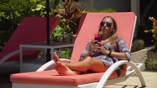 Chica con una copa de cóctel cerca de la piscina. — Vídeo de stock