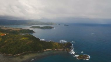 Tropik ada, plaj, kayalar ve dalgalar deniz manzarası. Catanduanes, Filipinler.