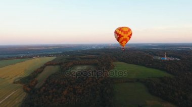 Sıcak hava balonu bir alanın üzerinde gökyüzünde.