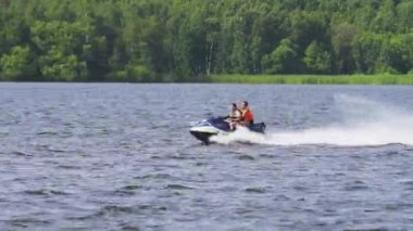 Göl kenarında jet ski üzerinde biniciler.