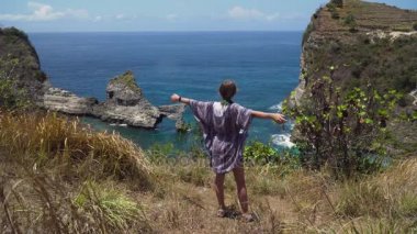 Uçurumun kenarında duran ve denize bakan bir kız. Bali, Endonezya