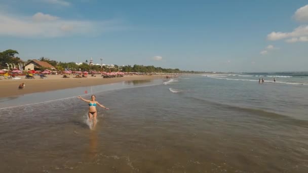 女孩在海滩上奔跑。印度尼西亚, 巴厘岛. — 图库视频影像