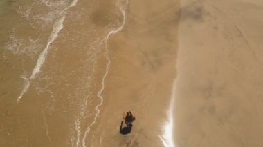 Kumsalda yürüyen bir kız. Bali, Endonezya.